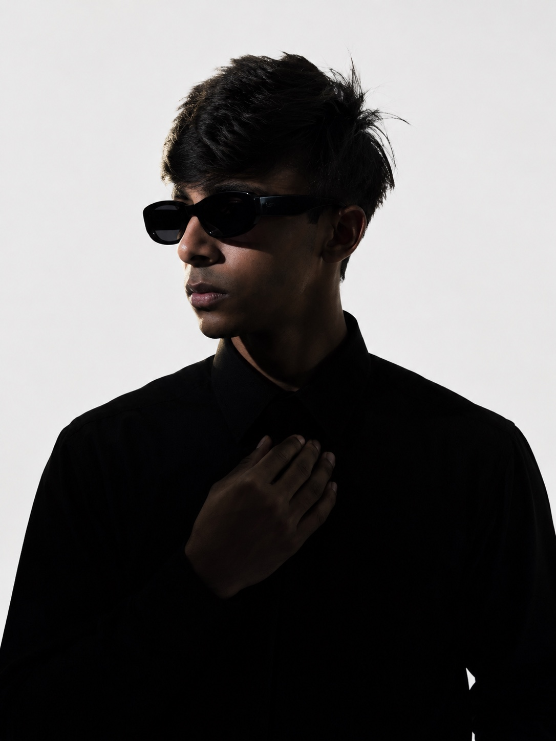 Ahammed Ayan in a high-contrast portrait wearing sunglasses and a black shirt